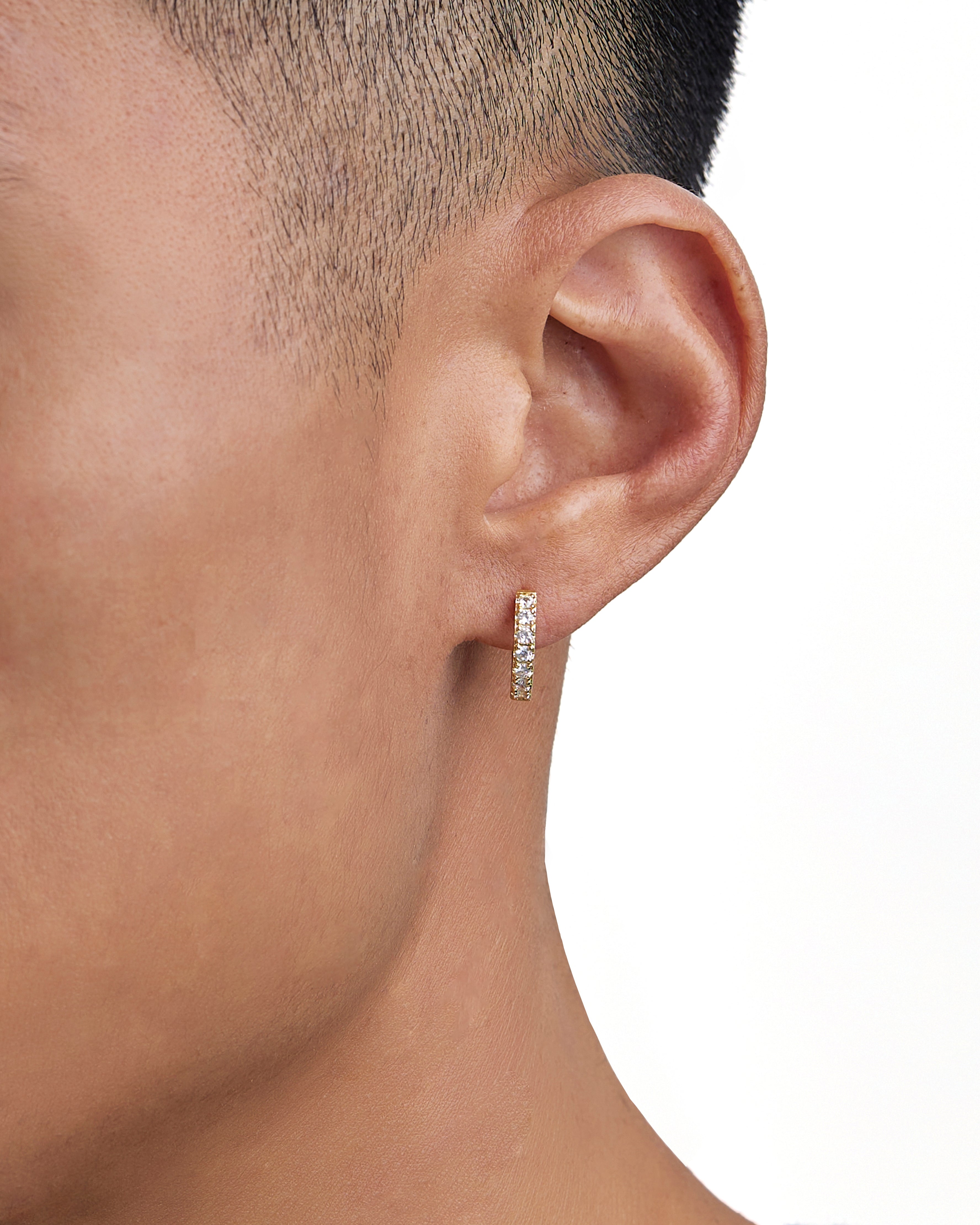 Model wearing 18k gold diamond earrings by Iceman Society