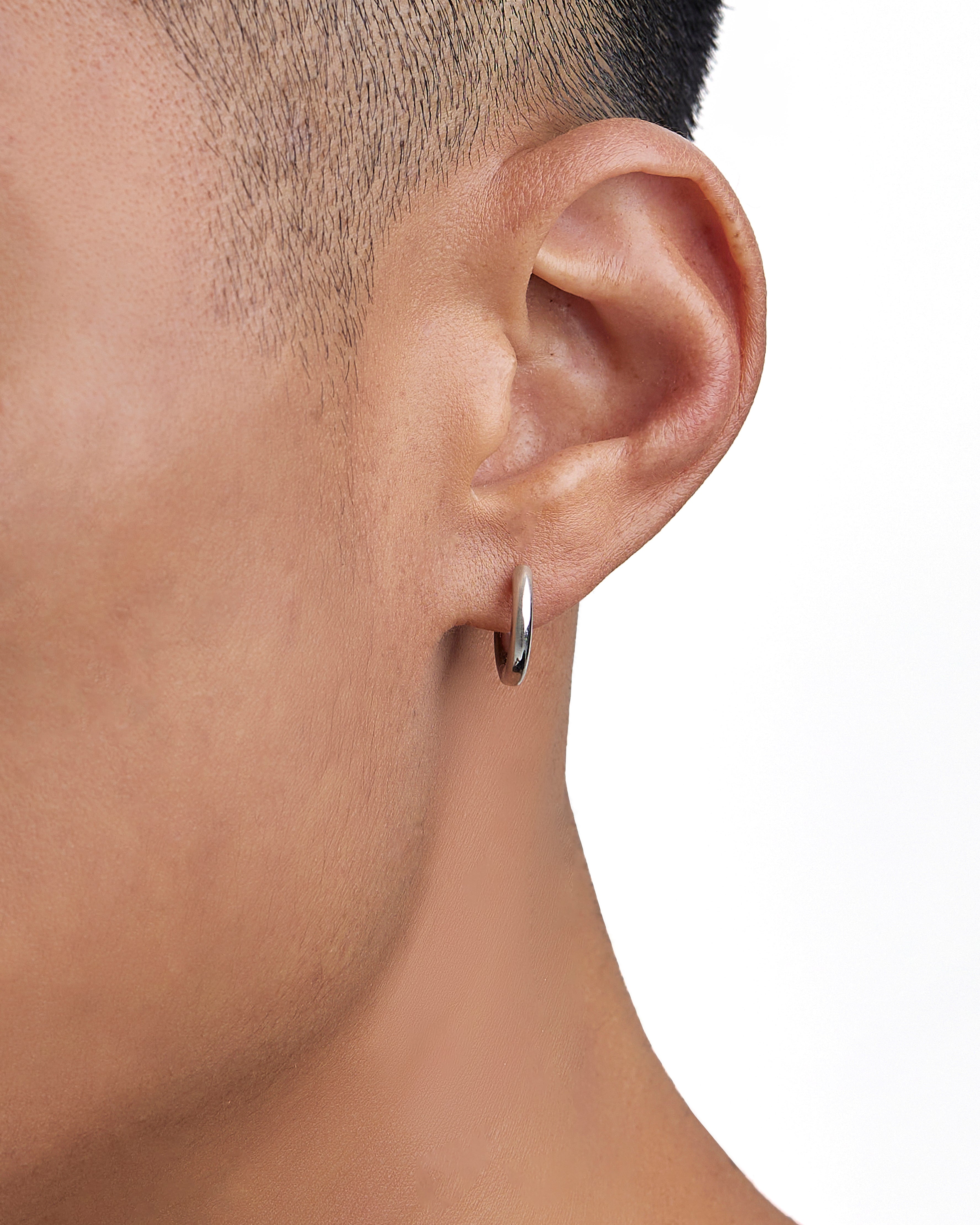 Model wearing white gold earrings by Iceman Society