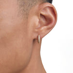 Model wearing 18k gold diamond earrings by Iceman Society