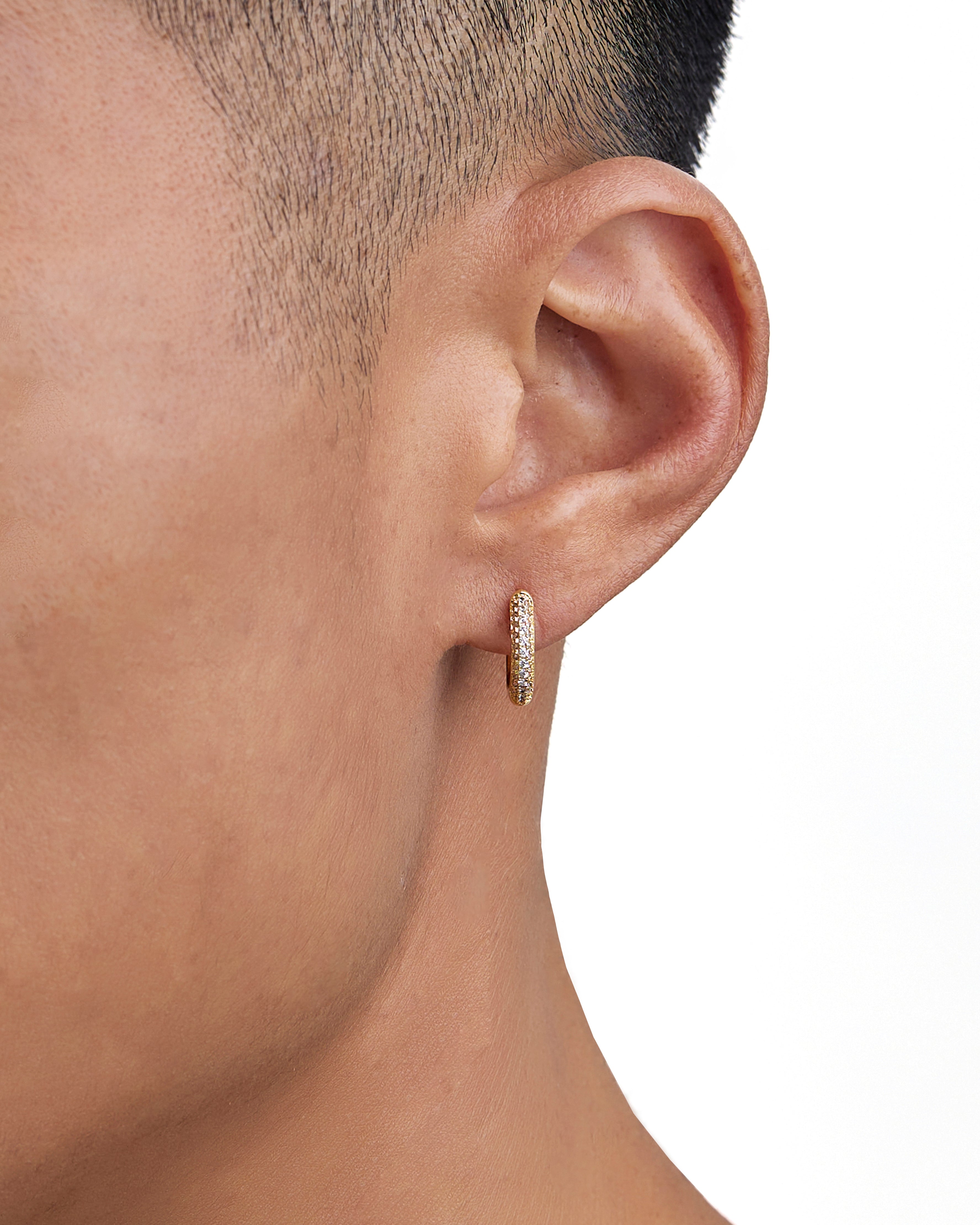 Model wearing 18k gold diamond earrings by Iceman Society