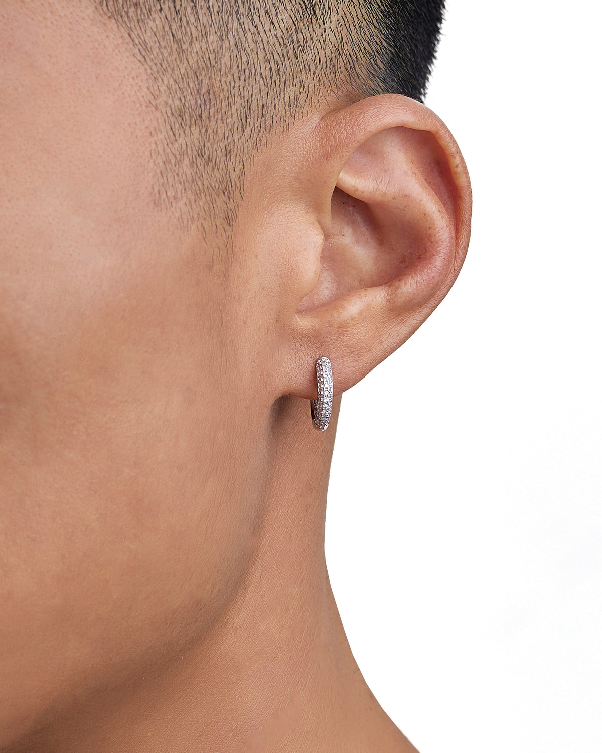 Model wearing white gold diamond earrings by Iceman Society